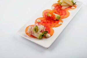 Smoked salmon fillet sliced and decorated with red caviar with zucchini photo