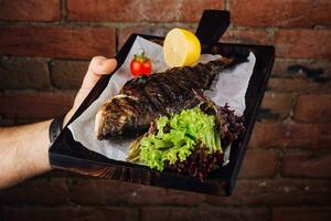 Served fried carp on wooden board photo