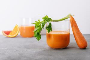 Carrot juice and fresh carrot closeup photo