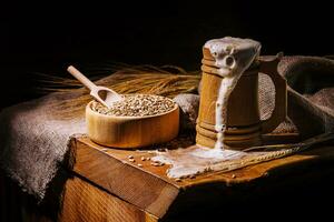 Wooden beer mug with beer and foam standing on a wooden table photo