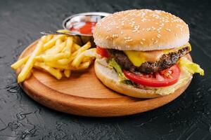 Fresh burger with french fries on wood photo