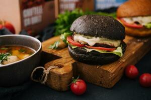 Modern black burger on wooden board photo