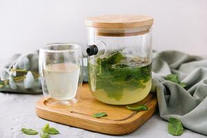 green tea in a jug and a cup with mint photo