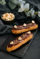 french eclairs with chocolate and hazelnuts photo