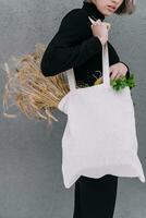 joven niña participación un paño bolso con orejas de trigo foto
