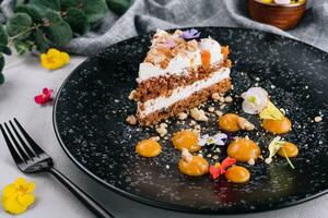 Carrot cake with walnuts on black plate photo