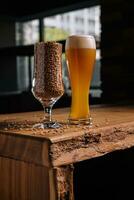 glass of beer and wheat in glass on wooden table photo