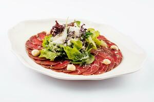 Veal carpaccio with parmesan cheese on white plate photo