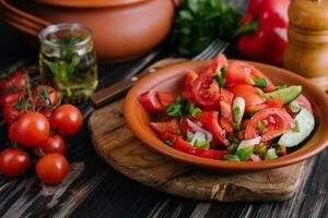 Tomato salad with cucumber, onion and parsley photo