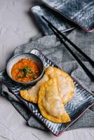 Homemade chebureks with filling and salsa sauce photo