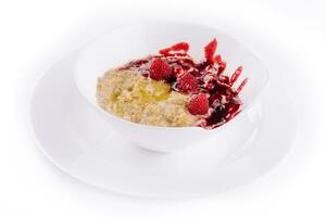Oatmeal rustic porridge with raspberries jam photo