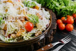 Fresh Caesar Salad on a Wooden Kitchen Table photo