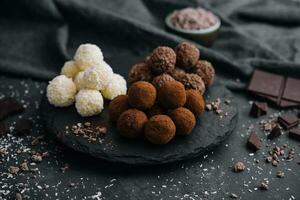 three types of chocolate balls on stone board photo