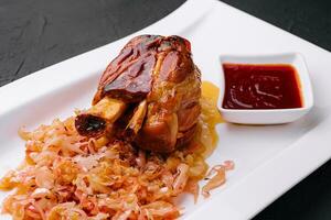 Bavarian pork knuckle with sauerkraut on plate photo