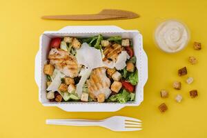 Caesar salad packed on craft box for take away photo