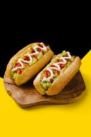 Two delicious hotdogs on wooden board photo