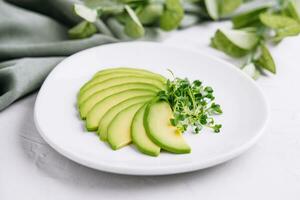 Sliced avocado on white plate photo