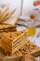 rebanada de dulce miel pastel en de madera tablero foto