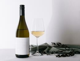 botella y vaso de blanco vino aislado en blanco antecedentes foto