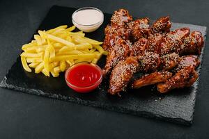 chicken wings with legs in Chinese sauce with french fries photo