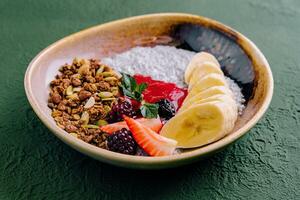 Healthy breakfast bowl of granola, yogurt and fruits photo