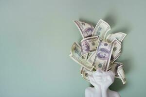 Thoughts about money, earnings creative concept. Plaster head with cash money on green background copy space photo