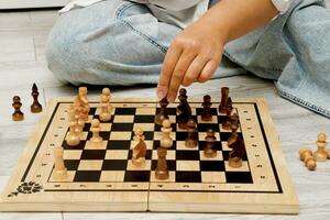 woman playing chess sitting on the floor at home with herself photo