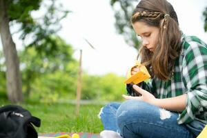 Little girl on vacation in the park with the craft of making a bird's beak with paper can use your fingers to move your mouth. photo