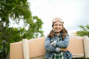 A little girl on vacation at the park with a pilot outfit and flying equipment. Run around and have fun with her dreams. photo