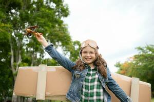 A little girl on vacation at the park with a pilot outfit and flying equipment. Run around and have fun with her dreams. photo