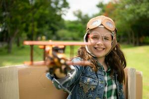 A little girl on vacation at the park with a pilot outfit and flying equipment. Run around and have fun with her dreams. photo