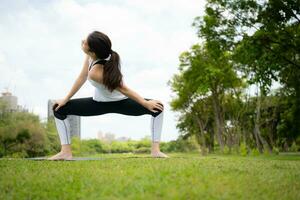 Young female with outdoor activities in the city park, Yoga is her chosen activity. photo