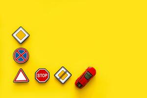 road signs with car on yellow background with copy space photo