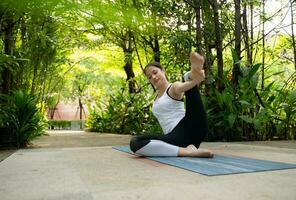 Young female in the garden there are wooden walkways and a tunnel of fresh green trees, with yoga activities for health photo