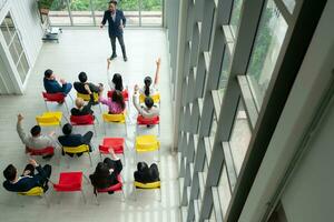 Top view of a group of business people sitting and listening to a presentation in a conference hall photo