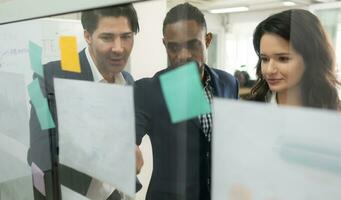 Group of business people discussing the charts and graphs showing the results of their successful teamwork photo