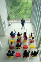 Top view of a group of business people sitting and listening to a presentation in a conference hall photo