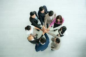 Top view of group of business people joining hands together in office to empower each other photo