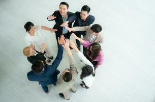 Top view of group of business people joining hands together in office to empower each other photo