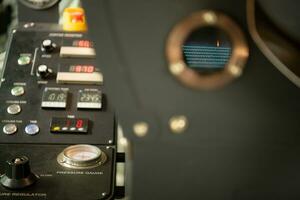 Coffee roaster machine with roasted coffee beans, close up photo