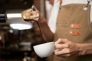 barista torrencial café dentro un taza en café comercio, de cerca foto