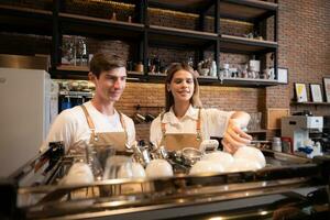 Barista working in cafe. Portrait of young male barista standing behind counter in coffee shop. photo