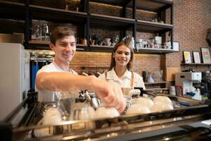 Barista working in cafe. Portrait of young male barista standing behind counter in coffee shop. photo