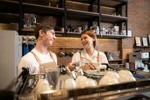 Barista working in cafe. Portrait of young male barista standing behind counter in coffee shop. photo