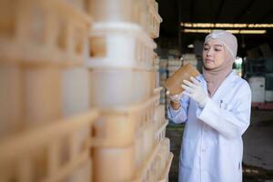 Portrait of a young scientist working in a laboratory She is examining the mushroom culture bottles in the mushroom house. photo