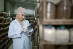 Young asian muslim female scientist doing research at a mushroom factory, examining mushroom leavening agent in a sterile and temperature-controlled room. photo