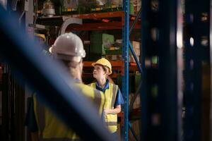 Side view of warehouse workers discussing inspecting goods brought into the warehouse for pre-stocking. photo