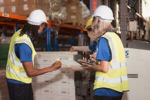 Side view of warehouse workers discussing inspecting goods brought into the warehouse for pre-stocking. photo