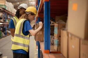 Young man and woman working together in warehouse, This is a freight transportation and distribution warehouse. Industrial and industrial workers concept photo