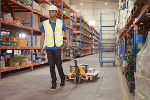 Warehouse workers pushing a pallet truck in a shipping and distribution warehouse. photo